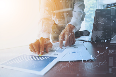 business documents on office table with smart phone and digital tablet and graph business with social network diagram and man working in the background