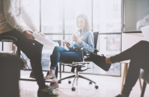 Teamwork concept, brainstorming. Businessman crew working with new startup project in modern loft. Woman holding smartphone hands. Horizontal, film effect