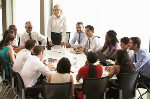 31047674 - businesswoman addressing meeting around boardroom table