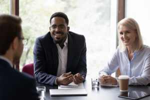 Happy diverse corporate teammates sharing ideas on briefing